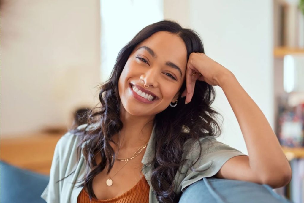 fille souriante assise sur le canapé