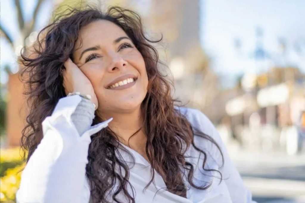 fille souriante assise sur un banc de parc