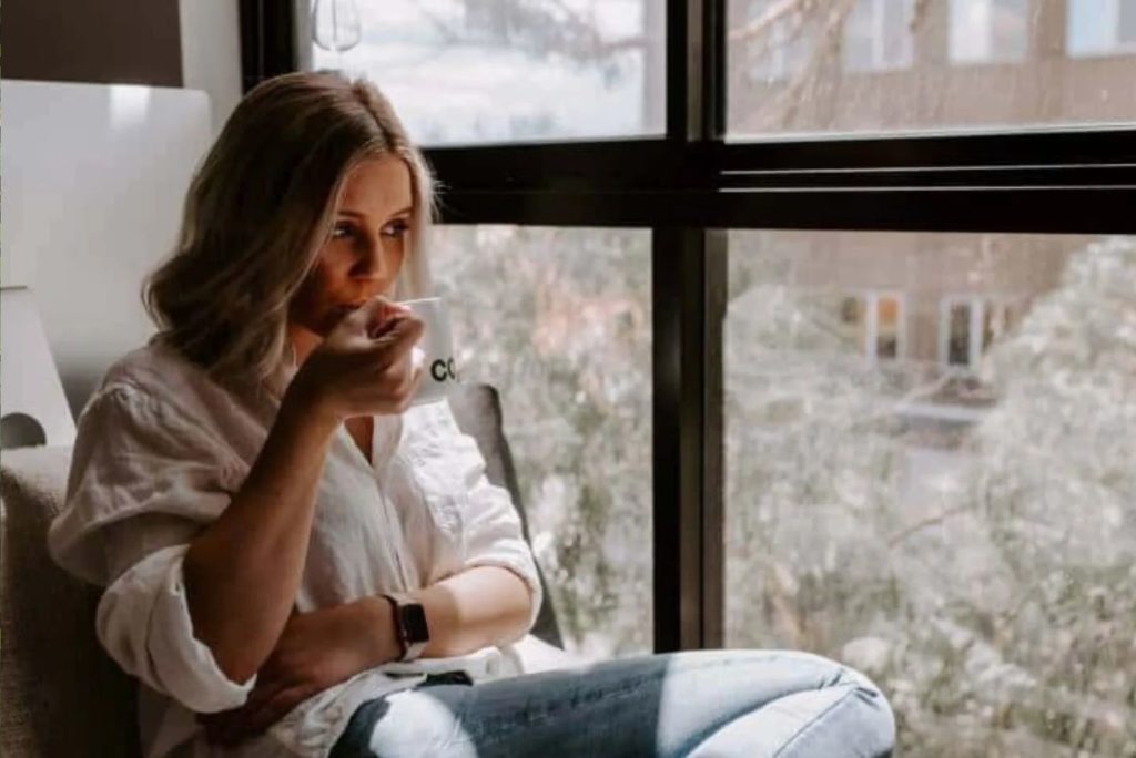 la fille boit du café près de la fenêtre