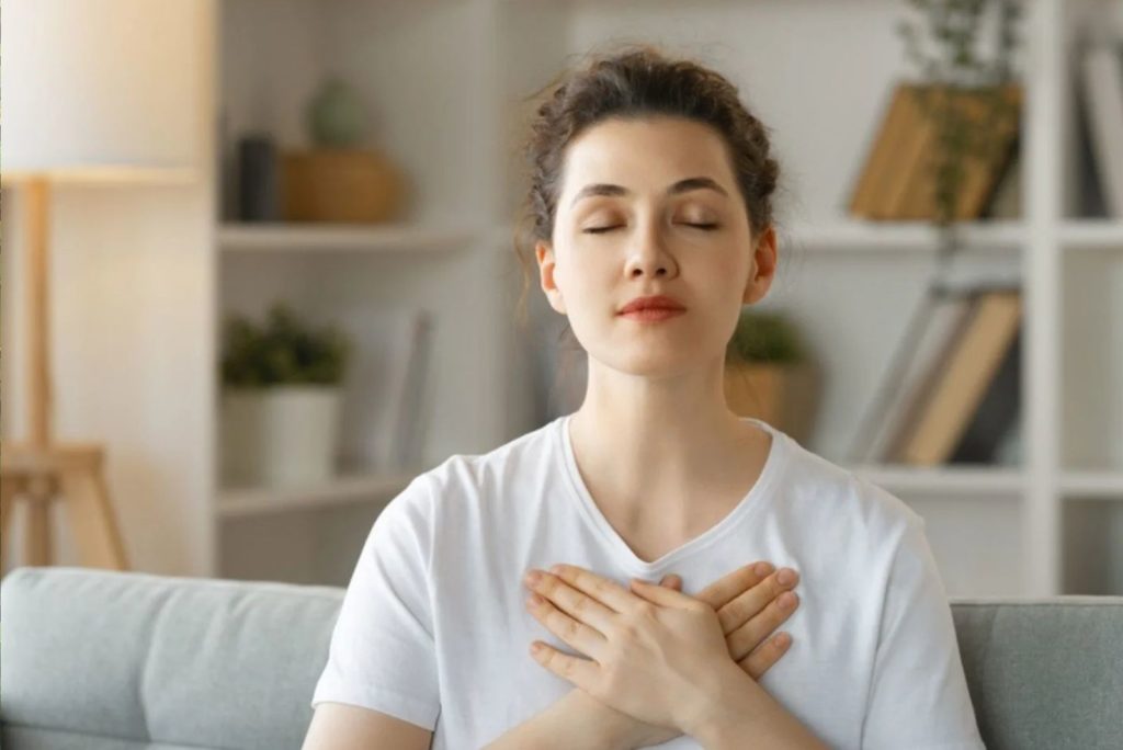 la fille est assise sur le canapé et médite