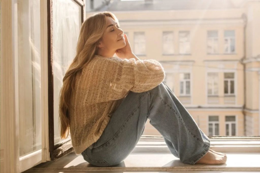 la fille profite du soleil près de la fenêtre