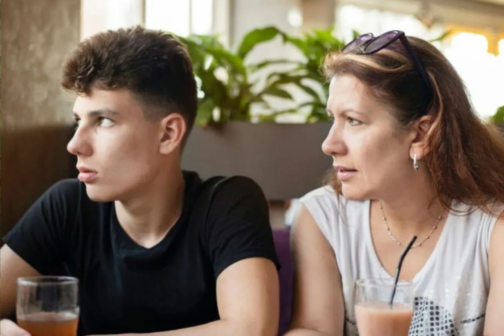 le garçon tourne la tête pendant que sa mère lui parle