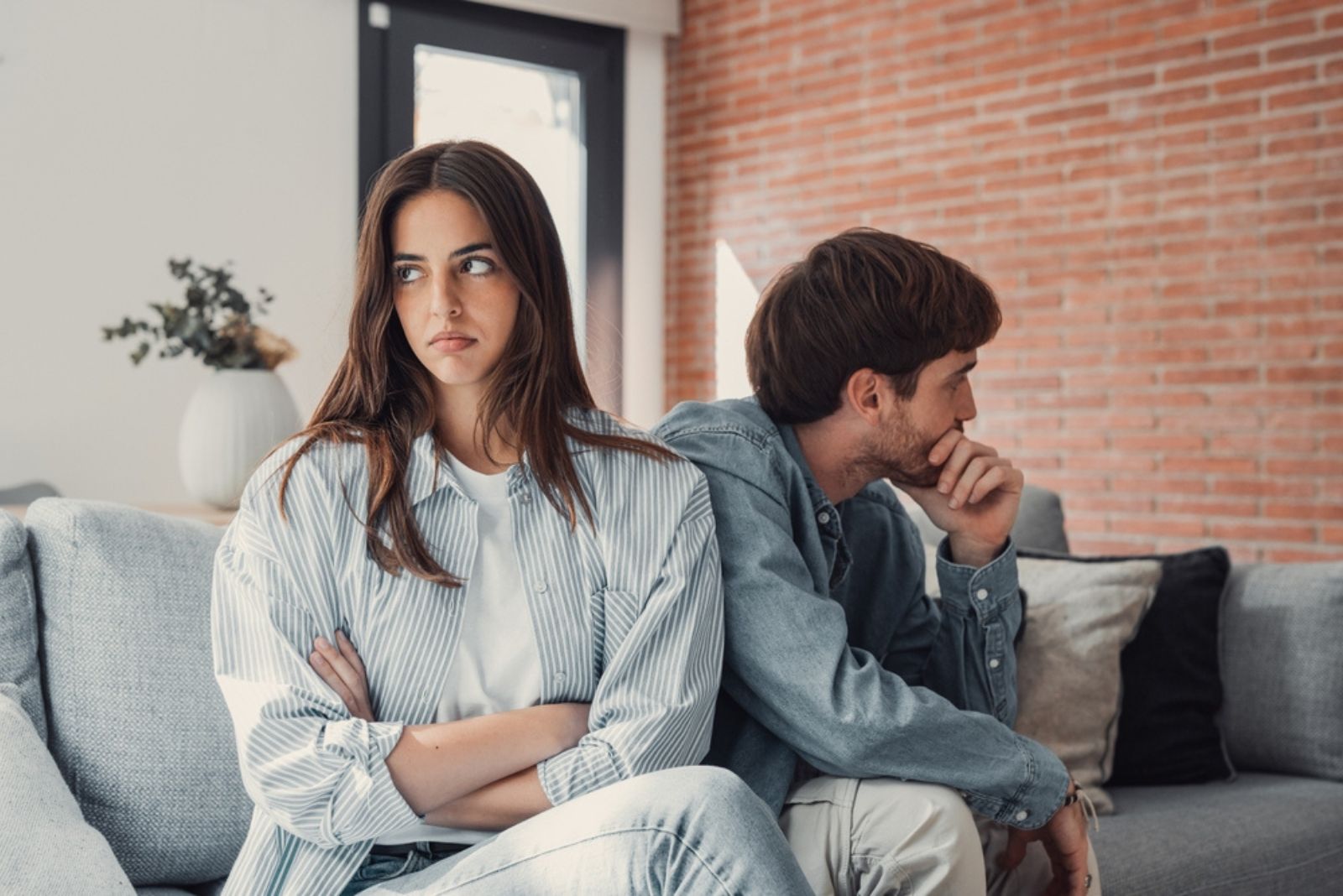 un couple se dispute assis sur le canapé