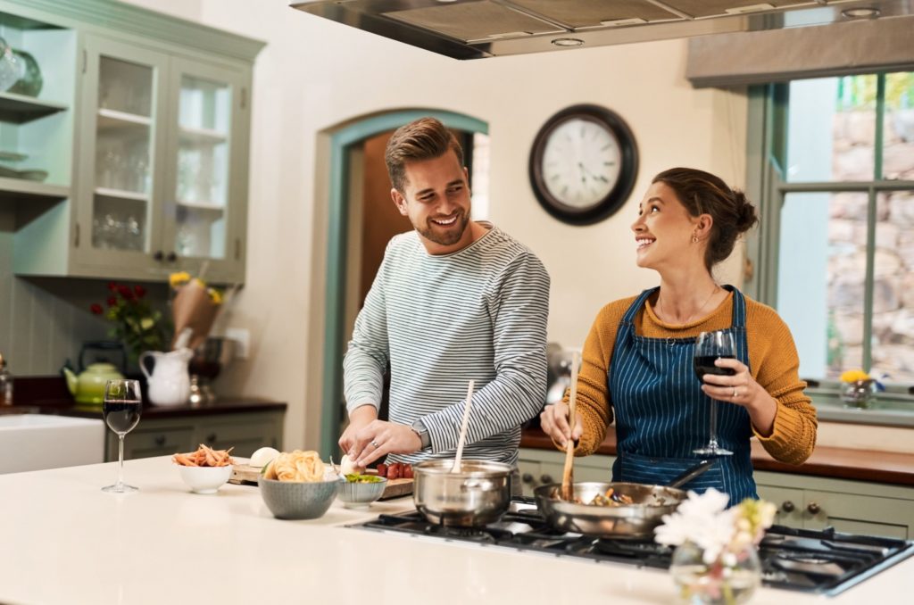 un homme et une femme cuisinent dans la cuisine