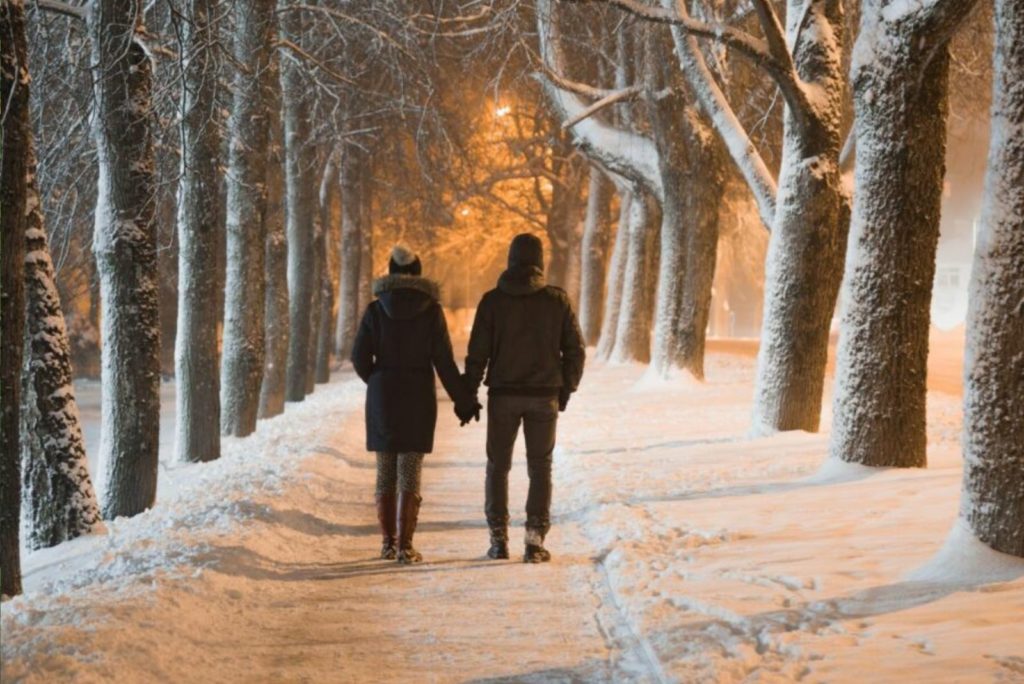 un homme et une femme profitent d'une promenade nocturne dans la neige