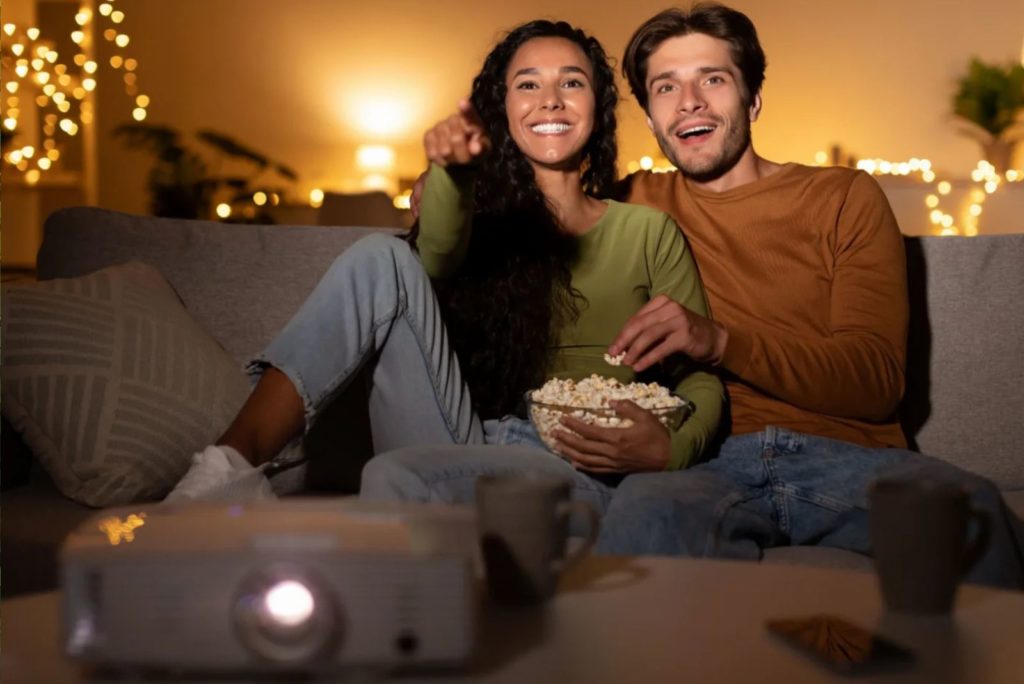 un homme et une femme regardent un film avec du pop-corn