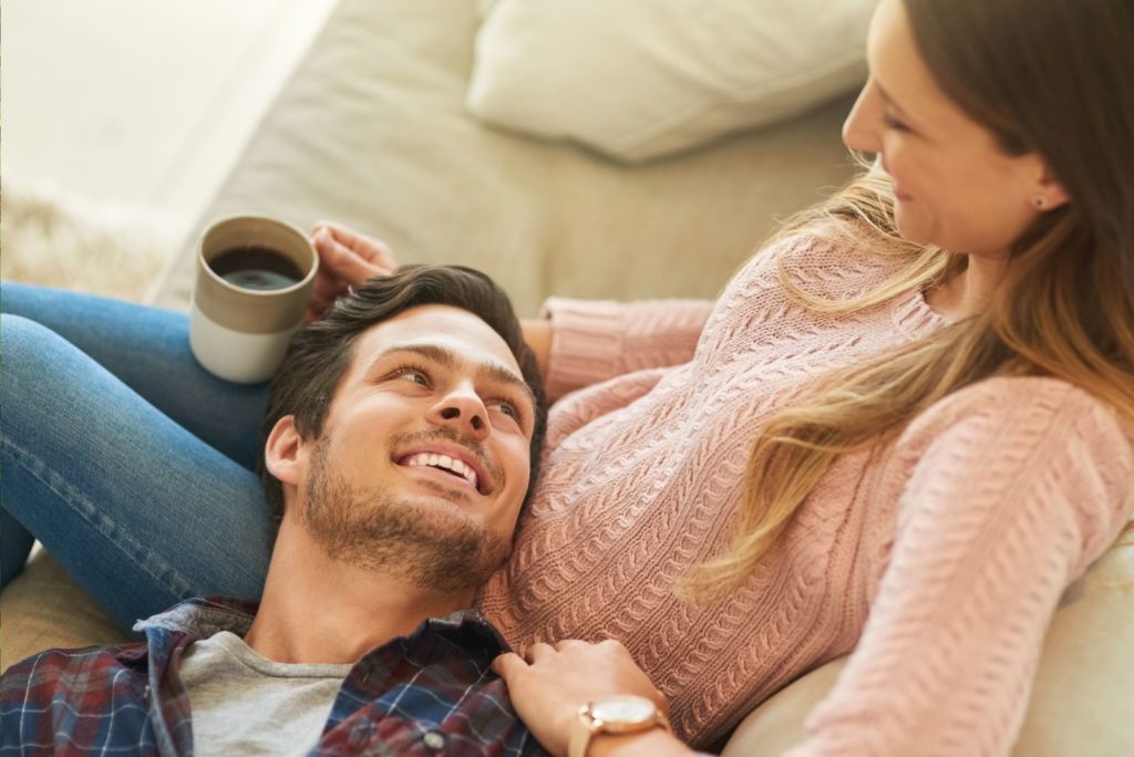 un homme souriant est allongé sur les genoux d'une femme