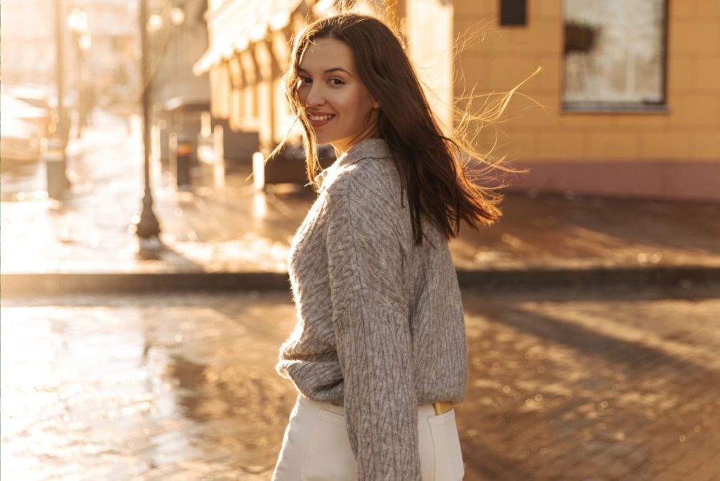 une fille souriante marche dans la rue