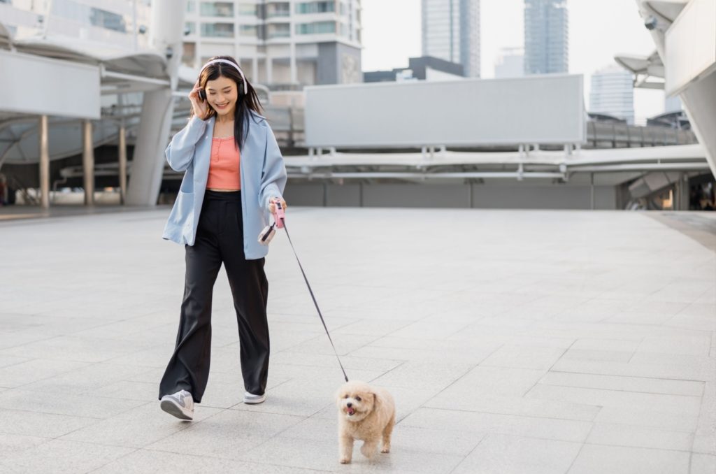 une fille souriante se promène avec son chien