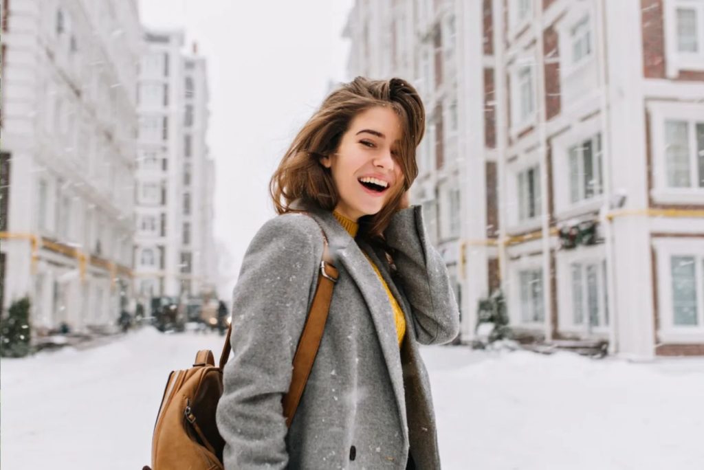 fille souriante dans un manteau gris