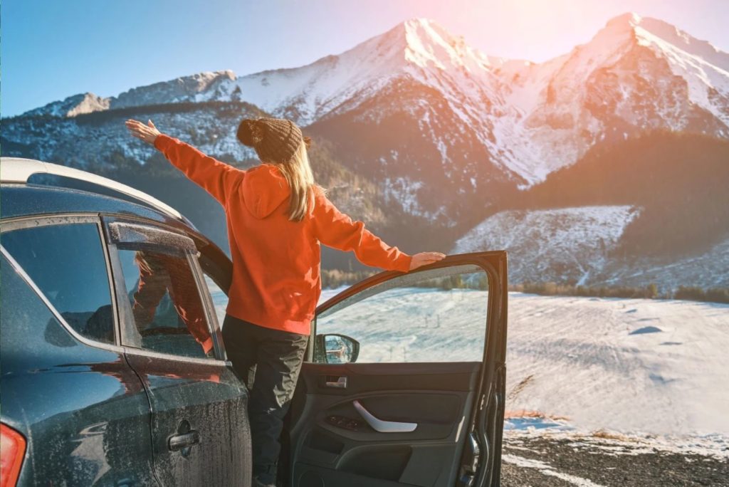 la fille est debout dans la voiture avec la porte ouverte