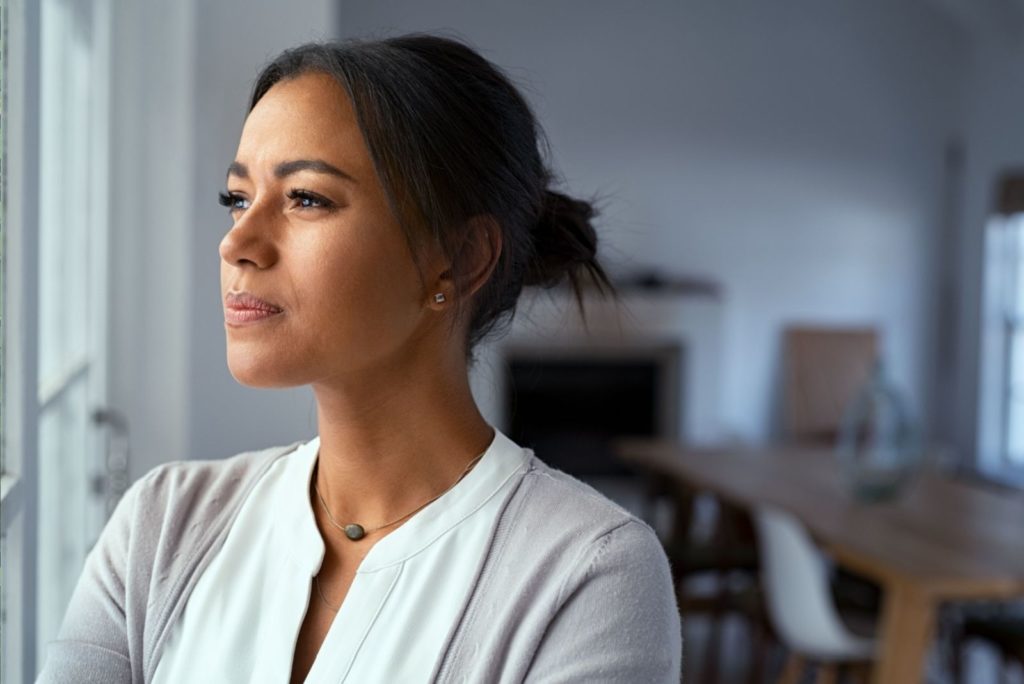 une fille pensive est assise près de la fenêtre